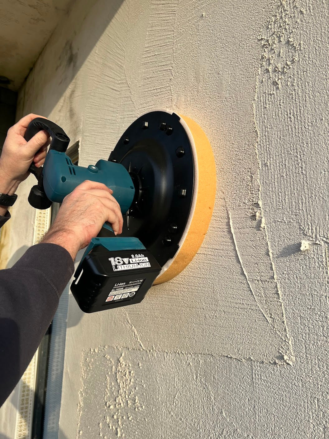 Plasterer using Skimflex battery power float to level mesh coat