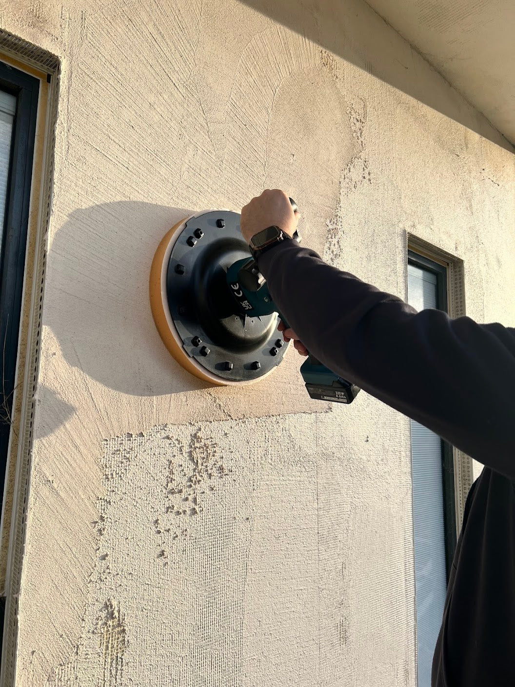 Skimflex cordless power float flattening render base coat on exterior wall