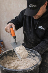 plasterer scooping plaster from bucket with bucket trowel