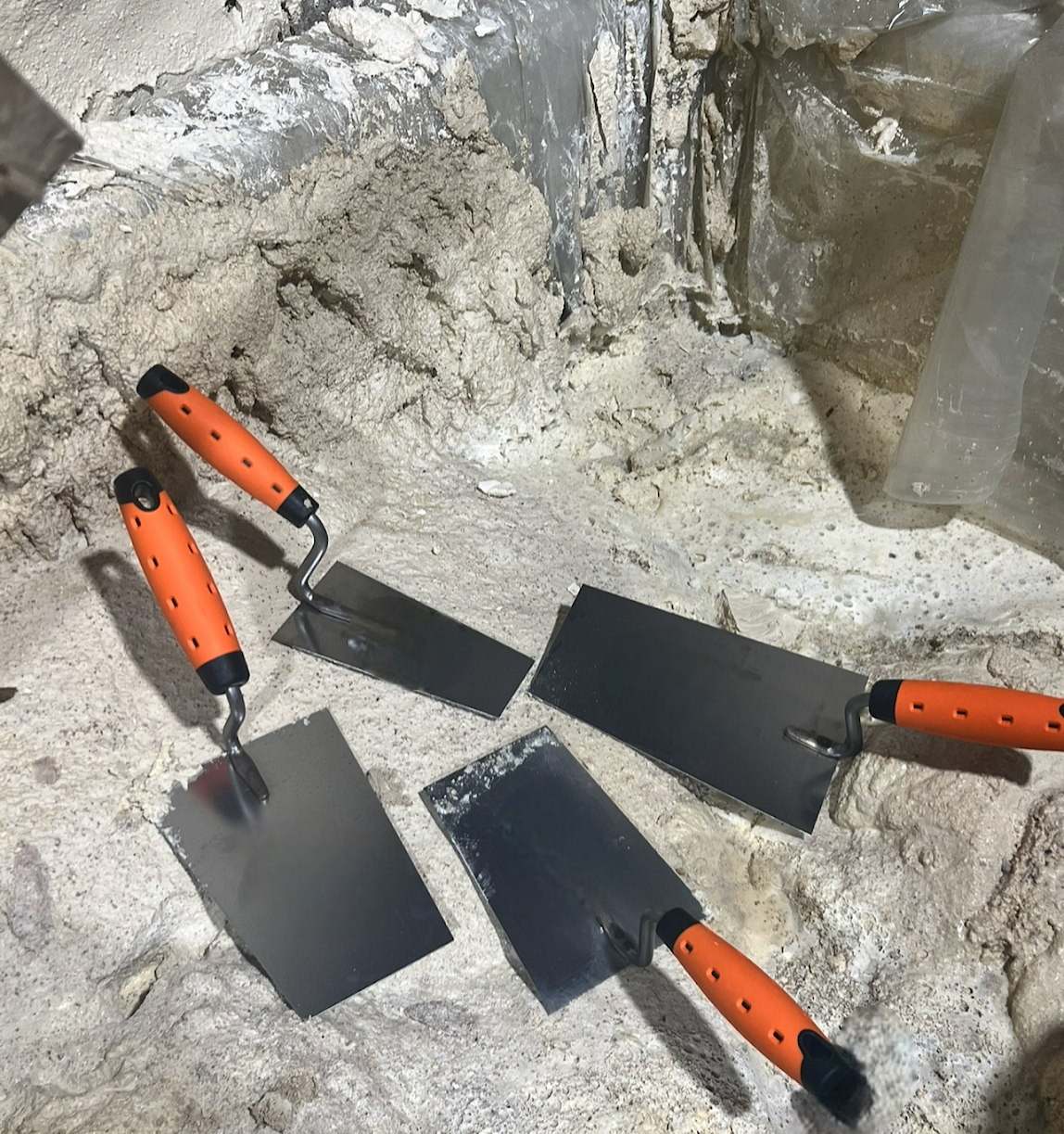 tradesman using bucket trowel plastering machine site