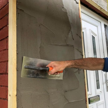 Person applying plaster to a wall using a Skimflex 007 trowel