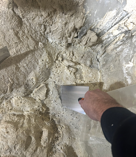 bucket trowel scooping plaster from mixing bucket